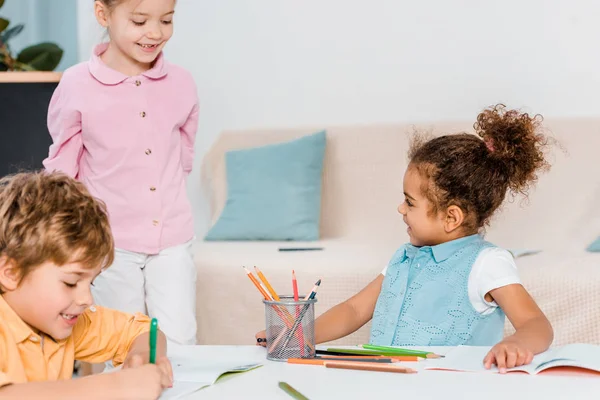 Cute happy multiethnic kids drawing together — Stock Photo