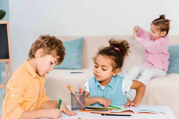 Adorables enfants multiethniques dessinant avec des crayons — Photo de stock