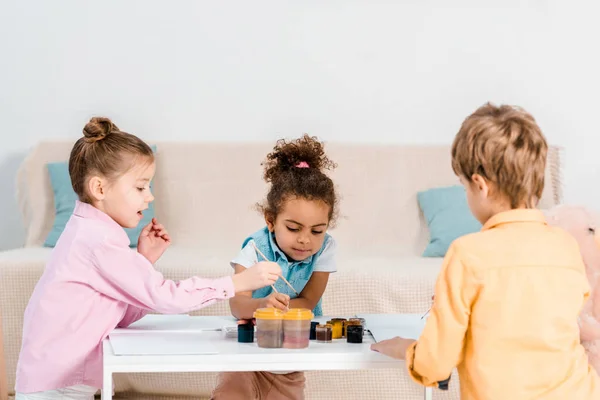 Adorable multiethnic children sitting and drawing together — Stock Photo