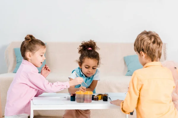 Entzückende multiethnische Kinder sitzen und zeichnen zusammen — Stockfoto