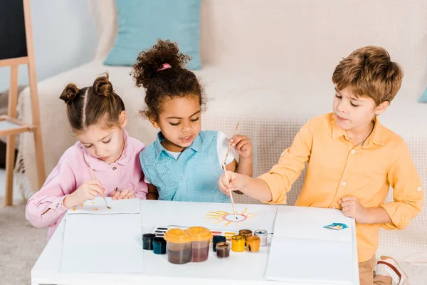 Belas crianças multiétnicas desenho com pincéis de pintura juntos — Fotografia de Stock