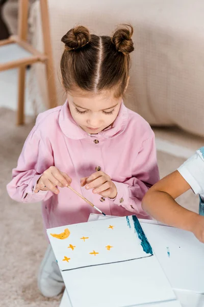 High angle view of adorable little child drawing picture with paints — Stock Photo