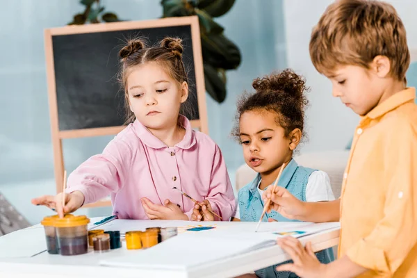 Entzückende multirassische Kinder malen mit Farben zusammen — Stockfoto