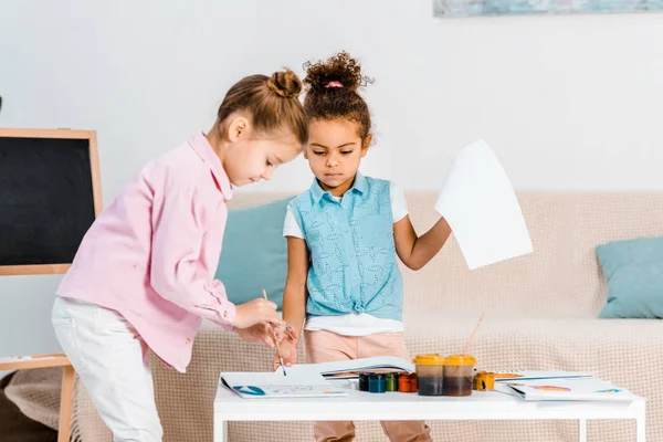 Adorable focused multiethnic children painting together — Stock Photo