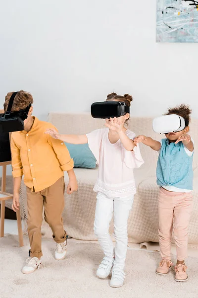 Adorabili bambini multietnici che giocano insieme in cuffie di realtà virtuale — Foto stock