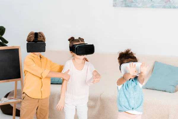 Crianças adoráveis usando fones de ouvido realidade virtual juntos — Fotografia de Stock