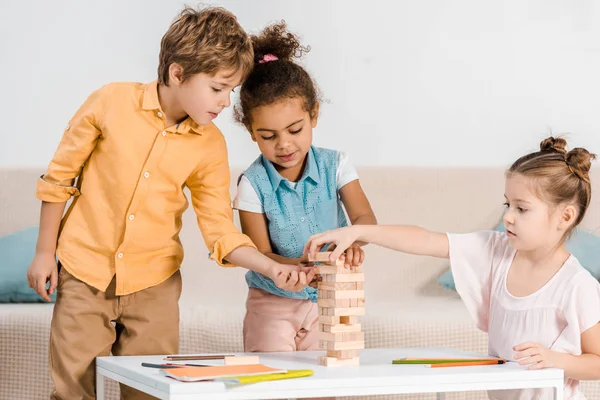 Niedliche kleine multirassische Kinder, die mit Holzklötzen spielen — Stockfoto