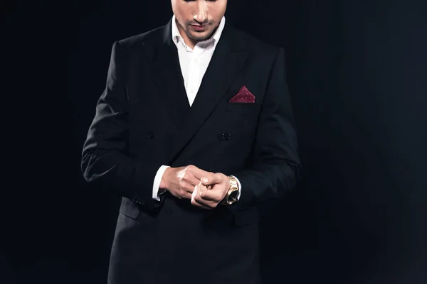 Cropped view of man in suit putting on watch isolated on black — Stock Photo