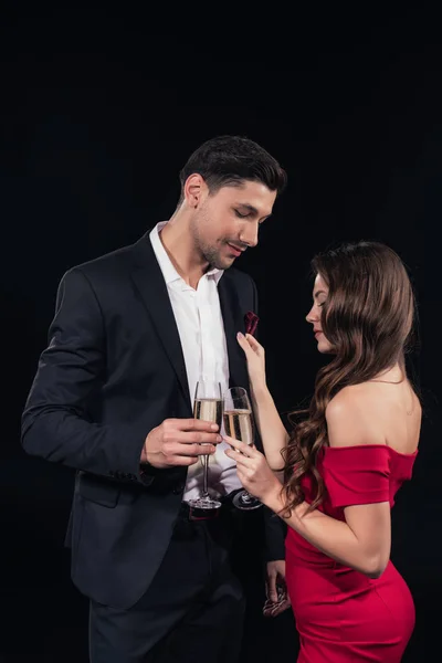 Hermosa pareja romántica sosteniendo copas de champán aisladas en negro - foto de stock