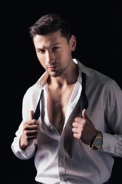 Handsome man in white shirt looking at camera and posing isolated on black — Stock Photo