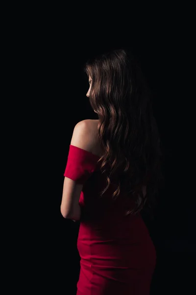 Visão traseira da mulher em vestido vermelho posando isolado no preto — Fotografia de Stock