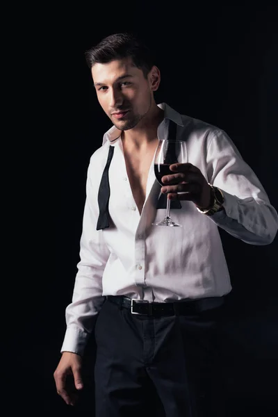 Man in white shirt looking at camera and holding glass of red wine isolated on black — Stock Photo