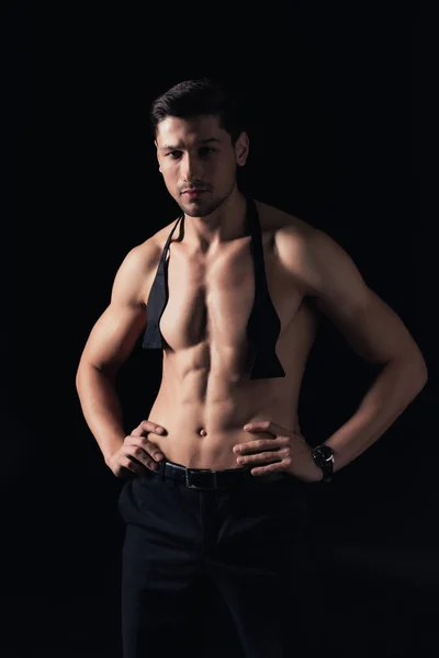 Handsome shirtless man standing akimbo and looking at camera isolated on black — Stock Photo