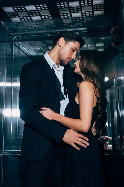 Belo casal romântico apaixonadamente olhando um para o outro e abraçando no elevador — Fotografia de Stock