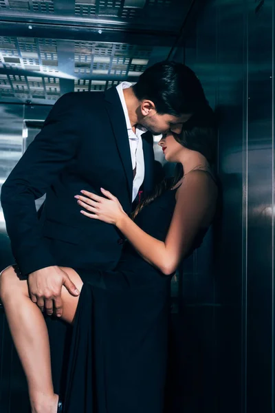Seductive couple kissing and hugging in elevator — Stock Photo