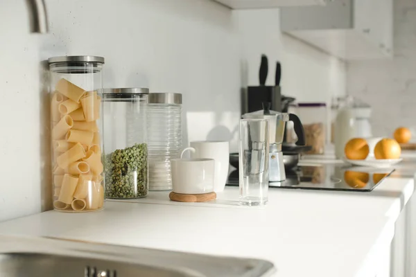 Cocina blanca con vajilla, frascos y comida — Stock Photo