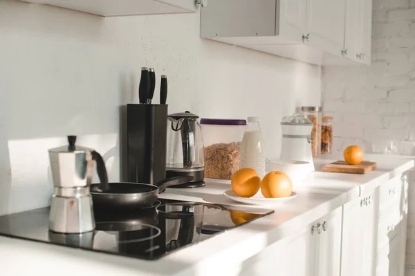 Солнце на белой кухне с посудой и фруктами — стоковое фото