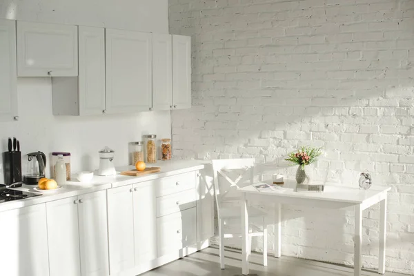 Lumière du soleil dans la cuisine moderne blanche avec ustensiles de cuisine — Photo de stock