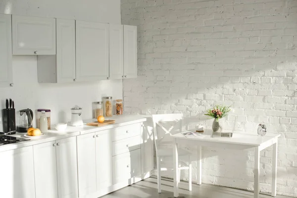 Sunlight in white modern kitchen with cooking utensils — Stock Photo