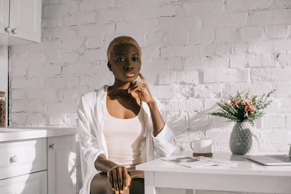 Belle femme afro-américaine assise dans la cuisine blanche — Photo de stock