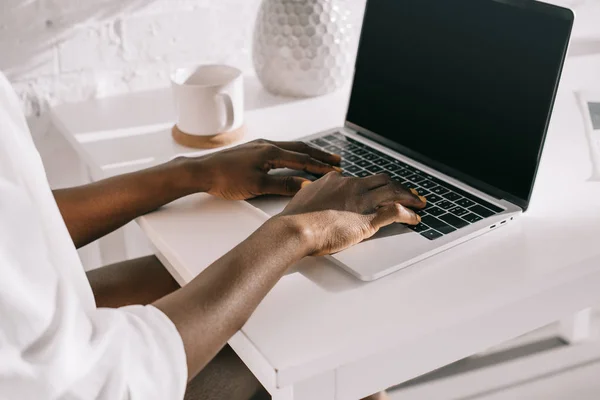 Vue recadrée de femme afro-américaine à l'aide d'un ordinateur portable avec écran blanc — Photo de stock