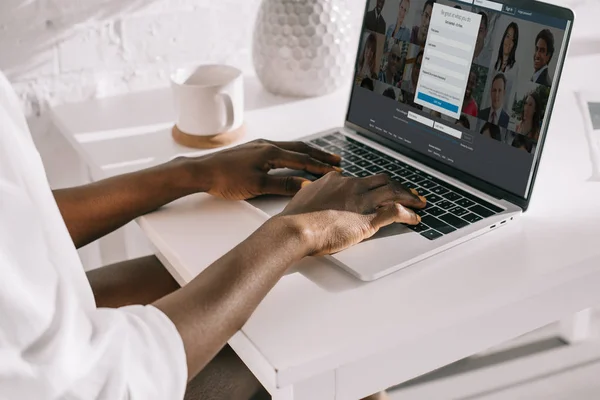 Vista cortada da mulher americana africana digitando no laptop com site linkedin — Fotografia de Stock