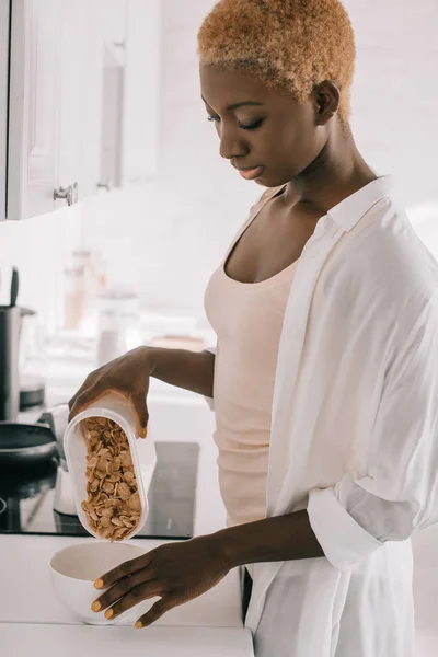 Mujer afroamericana preparando el desayuno en cocina blanca - foto de stock