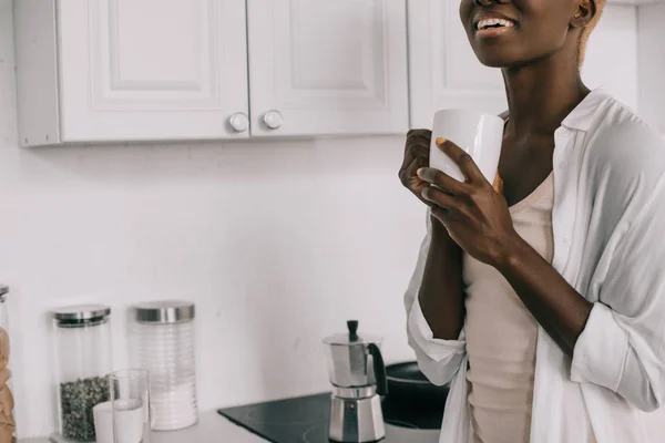 Vista ritagliata di allegra donna africana americana con tazza di caffè — Foto stock