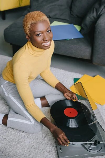 Africano americano mulher com cabelo curto segurando vinil recorde perto de recordista — Fotografia de Stock