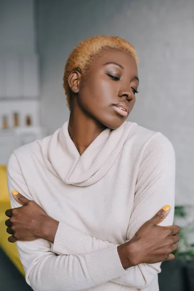 Selective focus of dreamy african american woman with crossed arms — Stock Photo