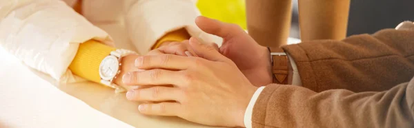 Vue recadrée du couple aimant tenant la main à la table — Photo de stock