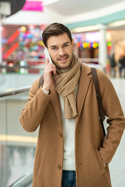 Homem bonito com smartphone no shopping — Fotografia de Stock