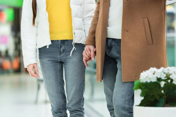 Vue recadrée de couple aimant dans des vêtements chauds tenant la main — Photo de stock