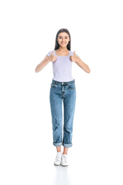 Mujer sonriente en jeans mostrando los pulgares hacia arriba aislado en blanco - foto de stock