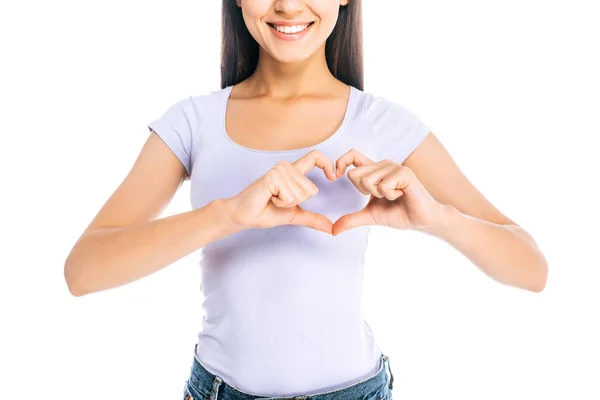 Обрізаний знімок усміхненої жінки, що показує знак серця ізольовано на білому — стокове фото