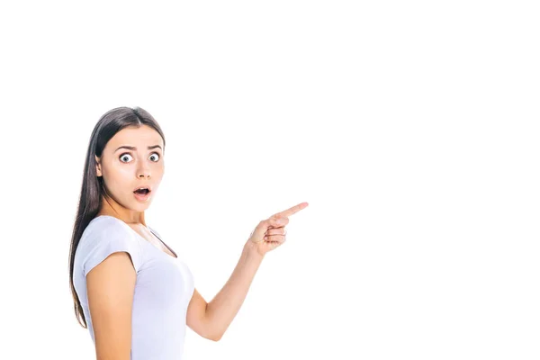 Side view of shocked young woman pointing away isolated on white — Stock Photo