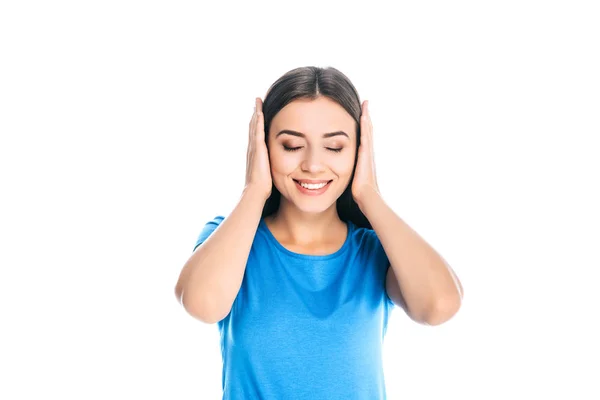 Retrato de atractiva mujer sonriente cubriendo las orejas con las manos aisladas en blanco - foto de stock