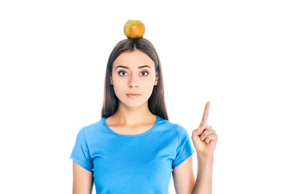 Porträt einer jungen Frau mit frischem Apfel auf dem Kopf, die vereinzelt auf weiß zeigt — Stockfoto