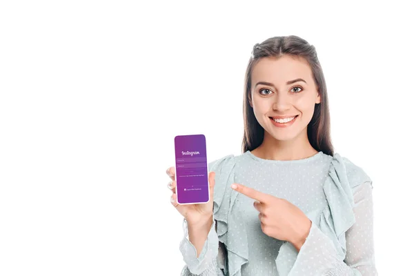 Mulher sorrindo mostrando smartphone com logotipo instagram na tela isolado no branco — Fotografia de Stock