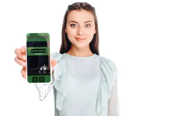 Mujer joven mostrando teléfono inteligente con signo de reserva en la pantalla aislada en blanco - foto de stock