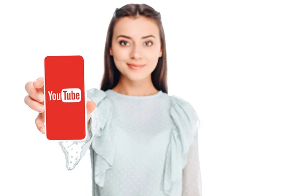 Junge Frau zeigt Smartphone mit Youtube-Logo auf weißem Bildschirm — Stockfoto