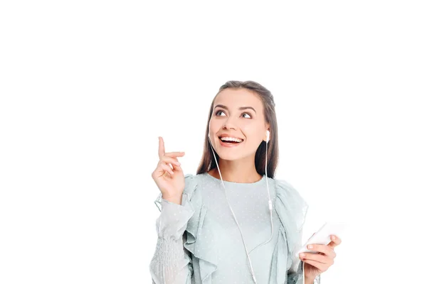 Ritratto di donna sorridente con smartphone che ascolta musica in auricolare isolato su bianco — Foto stock