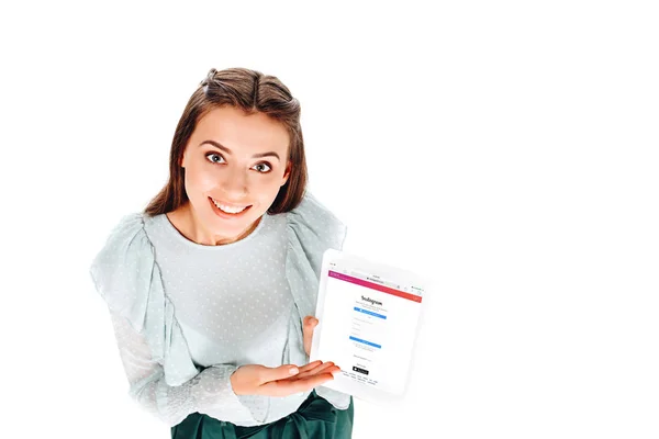 Hochwinkelaufnahme einer lächelnden Frau mit Tablet mit Instagram-Logo auf dem Bildschirm isoliert auf Weiß — Stockfoto