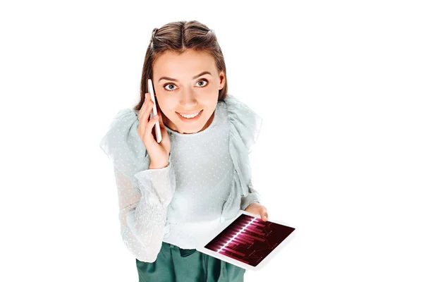 Vista de ángulo alto de la mujer sonriente con la tableta hablando en el teléfono inteligente aislado en blanco - foto de stock