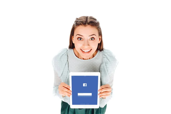 Vue grand angle de la femme souriante avec tablette avec logo facebook à l'écran isolé sur blanc — Photo de stock