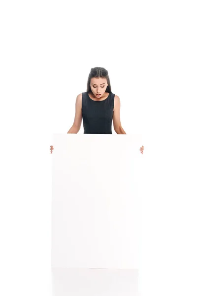 Chocado jovem mulher com banner em branco isolado no branco — Fotografia de Stock
