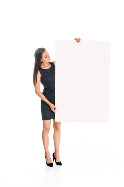 Frau in schwarzem Kleid blickt auf leeres Banner in den Händen isoliert auf weiß — Stockfoto