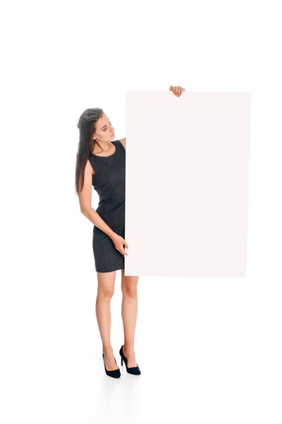 Woman in black dress looking  at blank banner in hands isolated on white — Stock Photo
