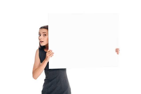 Portrait of shocked young woman holding blank banner isolated on white — Stock Photo