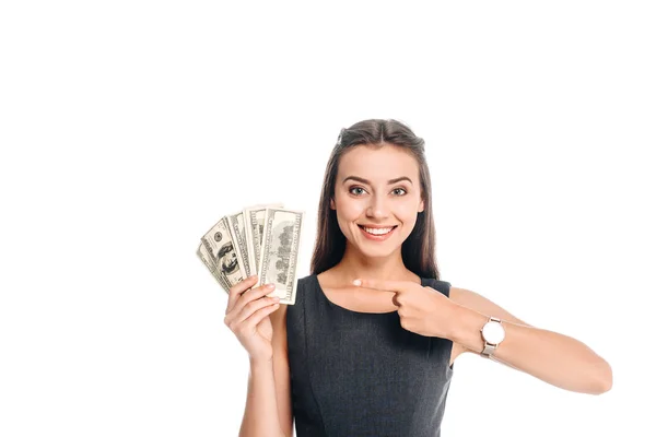 Mujer sonriente en vestido negro apuntando a billetes de dólar aislados en blanco — Stock Photo